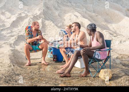 Vier junge Erwachsene, die Spaß am Strand haben Stockfoto