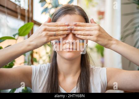 Porträt eines jungen russisch-ukrainischen Mädchens mit der Flagge der Ukraine und Russlands im Gesicht. Augen schließen. Das Konzept der Teilnahme der ukrainischen Stockfoto