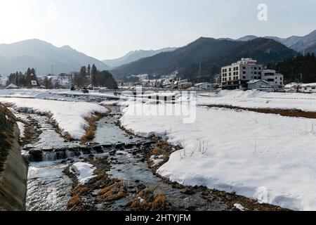 Yudanaka, Nagano, Japan, 2022/22/01 , Blick auf den Fluss Yomase und die Stadt Yudanaka Onsen im Winter 21/22. Stockfoto
