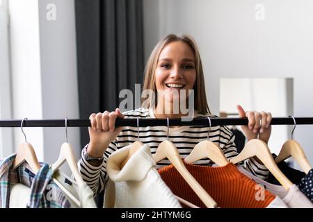 Beliebter Social-Media-Influencer, der zu Hause eine Videoaufzeichnung der neuen Bekleidungskollektion aufzeichnet und stylische Kleider der Kamera zeigt. Mode-Blogger machen b Stockfoto