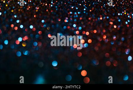 Neon Bokeh Hintergrund mit blauen, gelben und rosa Farben auf dunkel. Verwischen Sie die Halbton-Glitzer-Textur. Verschwommene Nachtlichter im Retro-Look. Stockfoto