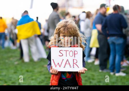 Junges Kind mit einem Plakat mit Stop war Message, Aktivismus und Menschenrechtsbewegung, Outdoor-Lifestyle. Kind trägt ein Schild Krieg stoppen. Russisch Stockfoto