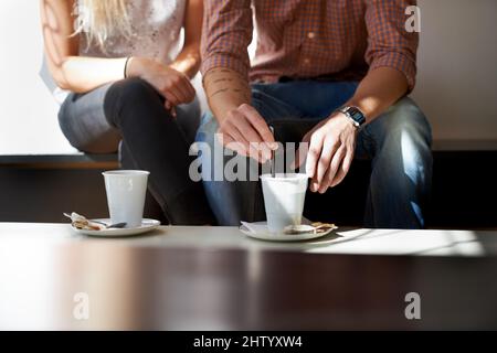 Sie lieben ihren Kaffee. Zugeschnittenes Bild eines jungen Paares, das Kaffee in seinem lokalen Café genießt. Stockfoto