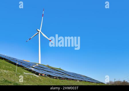 Karlsruhe, Deutschland - Februar 2022: Erneuerbare Wind- und Solarenergie. Windturbine neben der Photovoltaikanlage auf einem Hügel Stockfoto