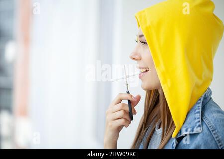 Hört auf zu rauchen, Frau schneidet eine Zigarette mit einer Schere Stockfoto