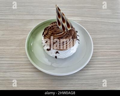 Pawlova-Dessert auf Meringuebaske mit Schokoladencreme und Schokoladendeko. Stockfoto