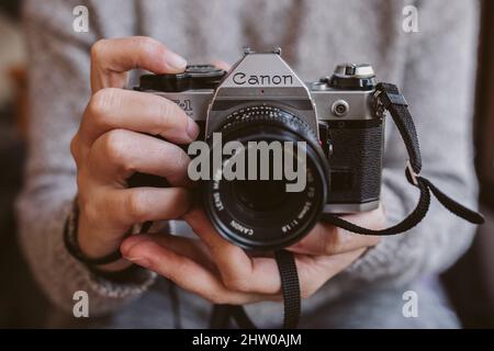 Canon AE 1 Vintage-Filmkamera 35 mm in der Hand. Stockfoto