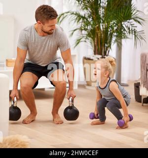 Du bist so stark. Die ganze Aufnahme eines Vaters und einer Tochter, die zusammen arbeiten. Stockfoto