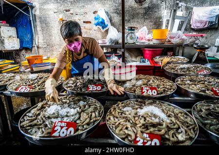 Bangkok, Thailand. 04. März 2022. Ein maskierter Verkäufer organisiert Garnelen, die auf dem Wongwian Yai Markt in Bangkok ausgestellt werden. Thailand öffnet sich vollständig geimpften internationalen Touristen wieder, indem es die Einschränkungen für „Test and Go“, das Quarantäneprogramm, lockere. Kredit: SOPA Images Limited/Alamy Live Nachrichten Stockfoto