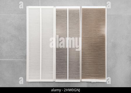 Verschmutzte G4 Filter und reinigen Sie den F7 Filter von der mechanischen Belüftung im Haushalt mit Wärmerückgewinnung, die auf grauen Keramikplatten liegt. Stockfoto