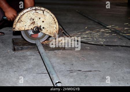 Der Arbeiter, der zum Schneiden eine Gehrungsäge mit Gleitmasse und kreisförmigem Blatt verwendet Stockfoto