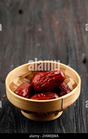 Angco oder Jujube getrocknete Unabi-Früchte, chinesische rote Datteln (Kurma Merah) auf Holzhintergrund, ausgewählter Fokus Stockfoto