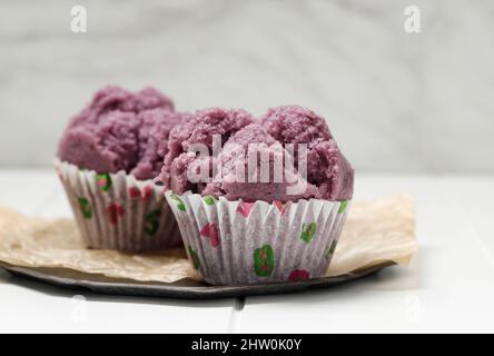 Kue Mangkok oder Kue Apem, traditionell gedünsteter indonesischer Cupcake Jajanan Pasar, isoliert auf Weiß Stockfoto