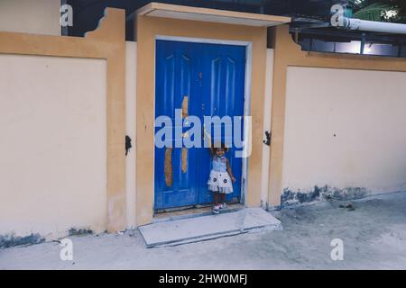 Maafushi, Malediven - 25. Juni 2021: Lächelnde Einheimische Kinder spielen auf den maledivischen Straßen Stockfoto