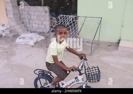 Maafushi, Malediven - 25. Juni 2021: Lächelnde Einheimische Kinder spielen auf den maledivischen Straßen Stockfoto