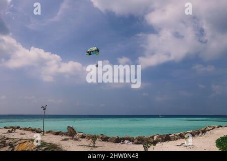 Maafushi, Malediven - 25. Juni 2021: Menschen in der Nähe des weißen Sandstrandes mit den Palmen und dem Hotelgebäude auf der maledivischen Paradies-Insel Stockfoto