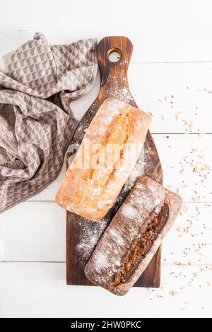 Hausgemachte frisch gebackene Chebatta aus zwei Arten von Mehl auf einem hölzernen Küchentafel und einem weißen Holztisch. Vertikale Ansicht von oben Stockfoto