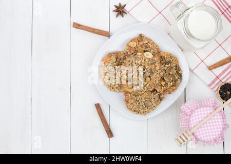 Süße Kekse und Milch mit Honig auf einem hölzernen Hintergrund. Hintergrund mit Kopierbereich Stockfoto