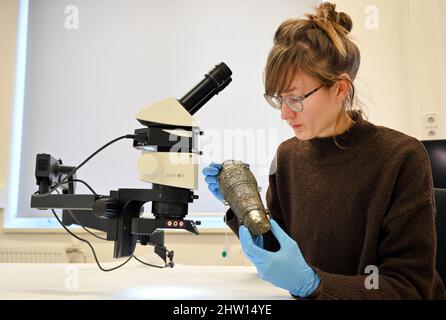 03. März 2022, Thüringen, Gotha: Susann Böhm, Metallrestauratorin, betrachtet eine Federhülse, ein Element, das als Dekoration auf der Kopfbedeckung der Janissaries, den Elitetruppen der osmanischen Armee, verwendet wird. Mehrere Objekte werden bei einer Presseveranstaltung zum Abschluss des Projekts "Dialog der Welten. Indizierung der Ethnographica.' Nach anderthalb Jahren hat die Stiftung Schloss Friedenstein Gotha im Rahmen des Projekts "Gotha Transdigital" die "vorbildliche Indizierung von Ethnographica in der Sammlung Schloss Friedenstein Gotha" abgeschlossen. Insgesamt wurden fast 1000 Objekte digitalisiert. Foto: Marti Stockfoto