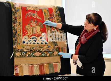 03. März 2022, Thüringen, Gotha: Marie-Luise Gothe, Textilrestauratorin, blickt auf eine Satteldecke, die Prinz Raden Saleh von Java einst Herzog Ernst II. Von Sachsen-Coburg und Gotha geschenkt hat. Zum Abschluss des Projekts "Dialog der Welten" werden auf einer Presseveranstaltung mehrere Objekte präsentiert. Indizierung der Ethnographica.' Nach anderthalb Jahren hat die Stiftung Schloss Friedenstein Gotha im Rahmen des Projekts "Gotha Transdigital" die "vorbildliche Indizierung von Ethnographica in der Sammlung Schloss Friedenstein Gotha" abgeschlossen. Insgesamt wurden fast 1000 Objekte digitalisiert. Foto: Marti Stockfoto