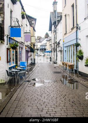 Eine kleine, verlassene gepflasterte Straße mit Cafés, die sich nach einer Regendusche durch die kleine Stadt Bowness-on-Windermere, Großbritannien, schlängelt Stockfoto