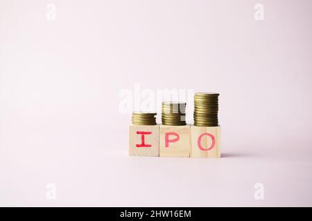 IPO-Text, anfängliches öffentliches Angebot auf Holzblock mit Münzstapel Stockfoto