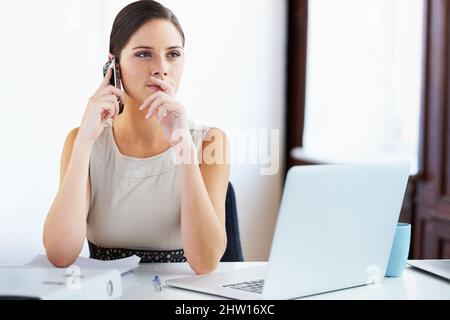 Lasst mich darüber nachdenken und mich zu Euch zurückwenden. Aufnahme einer jungen Geschäftsfrau, die in einem Büro arbeitet. Stockfoto