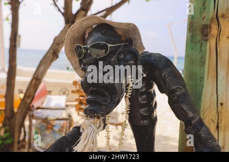 Maafushi, Malediven - 25. Juni 2021: Holzstatue des Einheimischen in Sonnenbrillen und Strandhut am Bikini Beach auf der Maafushi Insel Stockfoto