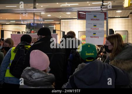 Berlin, Deutschland. 03. März 2022. Flüchtlinge, die aus der Ukraine angereist sind, stehen nach der Ankunft am Berliner Hauptbahnhof an einem Schalter, um ihre Reise mit dem Zug in andere deutsche Städte fortzusetzen. Quelle: Paul Zinken/dpa/Alamy Live News Stockfoto