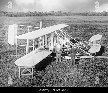 Eine Fotografie der Wright Machine aus dem frühen 20.. Jahrhundert, die von den Gebrüdern Wright, Orville und Wilbur Wright, den amerikanischen Pionieren der Luftfahrt, erfunden und entwickelt wurde. Am 17. Dezember 1903, 4 Meilen (6 km) südlich von Kitty Hawk, North Carolina, machten sie mit dem Wright Flyer den ersten kontrollierten, anhaltenden Flug eines angetriebenen, schwereren Flugzeugs als der Luft in den heutigen Kill Devil Hills. Die Brüder waren auch die ersten, die Flugzeugsteuerungen erfanden, die Flug mit festem Flügel möglich machten. Stockfoto