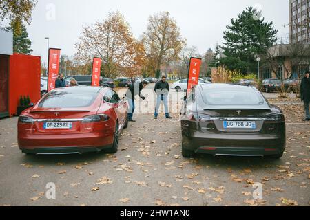 Paris, Frankreich - 29. Nov 2014: Zwei Männer, die neue elektrische Tesla Motors Autos P85 und P85 plus vergleichen wollen - und sich dabei die Kaufentscheidung zu nehmen Stockfoto