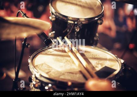 Ein Beat, der darauf wartet, geschehen zu können. Drum Kit auf einer Bühne mit einer Menge im Hintergrund. Stockfoto