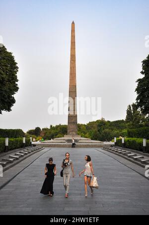 Foto aufgenommen im Juli 2013. Drei junge Frauen gehen vor dem Obelisken-Denkmal im Park des ewigen Ruhms in der ukrainischen Hauptstadt Kiew (Kiew). Stockfoto