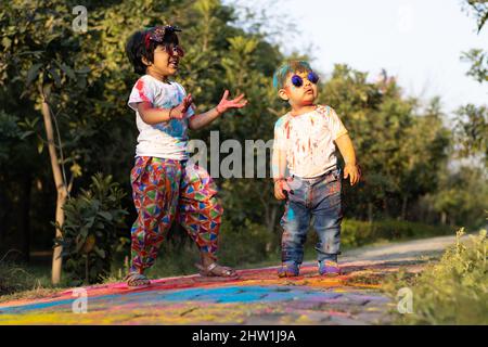 Happy Asian Indian Kids Boy Und Girl Genießen Das Festival Der Farben Mit Holi Color Powder Genannt Gulal Oder Rang Stockfoto