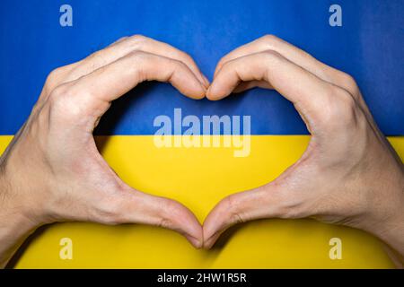 Handherz auf einer Ukraine-Flagge Stockfoto