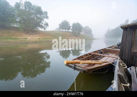 Frankreich, Maine-et-Loire (49), ein Toue caban?e und sein Boot, zwei traditionelle Holzboote, die in einem sekundären Arm der Loire (UNESCO-Weltkulturerbe) angedockt sind, Sonnenaufgang im Nebel Stockfoto