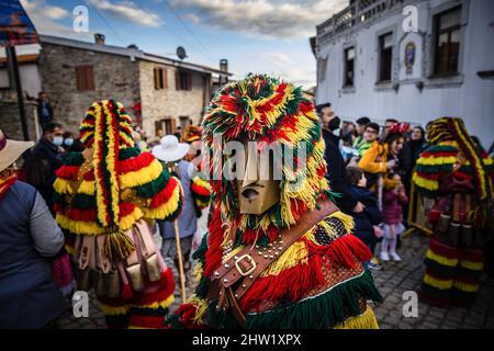 Ein Caretho durchläuft die Menge, bevor er die Parade des Podencarnevals beginnt. Im portugiesischen Dorf Podence, in der Gemeinde Macedo de Cavaleiros, tragen Männer während des Karnevals die traditionelle Tracht, bekannt als "Caretos", tragen Messing- oder Holzmasken und tragen bunte Wollkostüme. Sie schreien und jagen Menschen auf den Straßen, um sie zu verjagen, insbesondere alleinstehende Frauen. Caretos de Podence wurde am 2019. Dezember von der UNESCO zum immateriellen Kulturerbe der Menschheit erklärt. Das Ereignis endet mit der Verbrennung von Entrudo (einem riesigen Caretho). (Foto von Henrique Casinhas/SOPA Images/Sipa Stockfoto