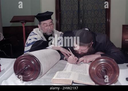 Rabbi Leonard Tann schreibt im vorletzten Brief auf die Tora-Schriftrolle. Der Oberrabbiner Jonathan Sacks war Ehrengast für die Aufnahme der letzten Briefe in eine neue Sefer-Torah in der Synagoge der hebräischen Kongregation Singers Hill am Sonntag, dem 15. März 1998. Mitglieder der Gemeinde sowie der Oberrabbiner fügten jeweils einen einzigen Brief hinzu. Stockfoto