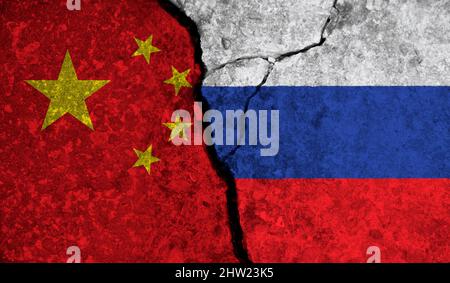 Politische Beziehungen zwischen China und russland. Nationalflaggen auf rissem Betongrund Stockfoto