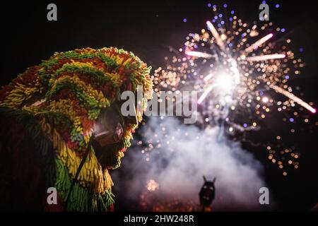 Macedo de Cavaleiros, Portugal. 28.. Februar 2022. Caretos führt religiöse Rituale während der Verbrennung der Zaubermaske während der Feier des Karnevals in Podence durch.im portugiesischen Dorf Podence, in der Gemeinde Macedo de Cavaleiros, tragen Männer während des Karnevals die traditionelle Tracht, die als "Caretos" bekannt ist, Tragen Sie Masken aus Messing oder Holz und tragen Sie bunte Wollkostüme. Sie schreien und jagen Menschen auf den Straßen, um sie zu verjagen, insbesondere alleinstehende Frauen. Caretos de Podence wurde am 2019. Dezember von der UNESCO zum immateriellen Kulturerbe der Menschheit erklärt. Die Veranstaltung endet mit der BU Stockfoto