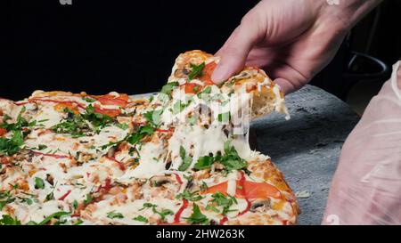 Scheibe heiße Pepperoni-Pizza, großes Käsemittagessen oder Abendessen mit Käse. Rahmen. Köstliche leckere Fastfood italienisch traditionell auf Holzbretttisch. Stockfoto