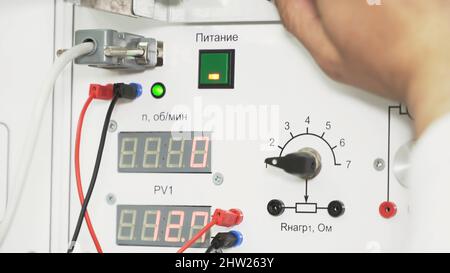 Elektronischer digitaler Bremssattel auf weißem Armaturenbrett. Industrieller Hintergrund mit einer männlichen Hand mit professionellem Werkzeugsattel, Messgenauigkeit. Stockfoto