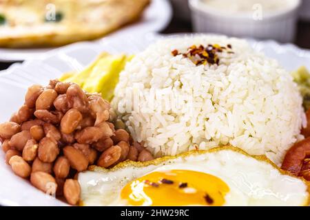 Reisgericht mit brasilianischen Bohnen, Spiegelei und Salat, hausgemachte Speisen Stockfoto