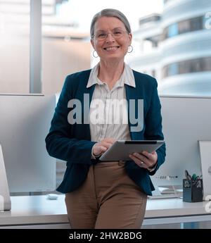 Lassen Sie sich nicht von Kritik ablenken. Aufnahme einer reifen Frau, die im Büro ein Tablet benutzt. Stockfoto