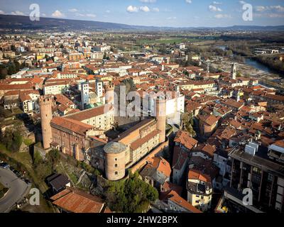 Luftaufnahme des historischen Zentrums mit dem Schloss mit seinen roten Türmen im Vordergrund. Ivrea, Italien - März 2021 Stockfoto