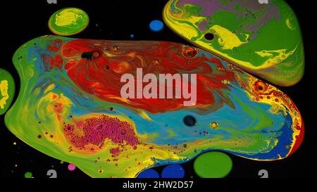Oberfläche mit Acrylfarbe Flecken von rot, grün, blau, rosa, eine gelbe Farben. Nahaufnahme von Flüssigfarben, die isoliert auf schwarzem Hintergrund gemischt werden. Stockfoto
