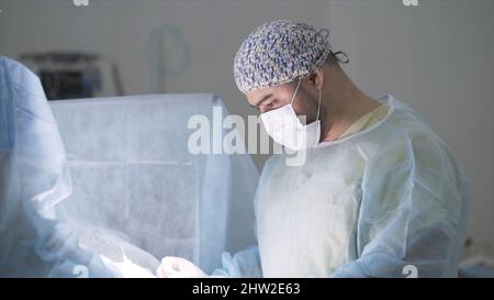 Professionelle Chirurgen operieren unter Narkose. Aktion. Zwei Chirurgen konzentrieren sich auf die Durchführung komplexer Operationen unter Narkose. Stockfoto