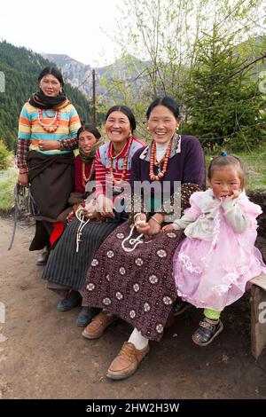 Buddhisten Frauen und Kinder tibetischen Erbes sitzen und entspannen sich in der Nähe des Kerti (oder Kirti) Gompa-Tempels in Langmusi. Volksrepublik China. Langmusi liegt am Rande des tibetischen Hochplateaus. (125) Stockfoto