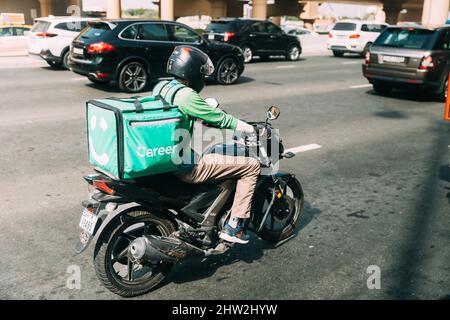 Dubai, VAE, Vereinigte Arabische Emirate - 28. Mai 2021: Kurier auf dem Roller, der Lebensmittel liefert. Careem ist ein Unternehmen, das eine Tochtergesellschaft von ist Stockfoto