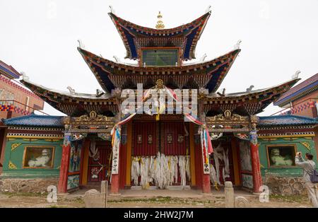 Dreifach überdachtes chinesisches Dach. Traditionelle Hüftdächer mit einer Kurve und Aufschwüngen, die an den Ecken des Tempeldachs mit fliegenden Dachrinnen aufsteigen Langmusi, China. VRC. (125) Stockfoto